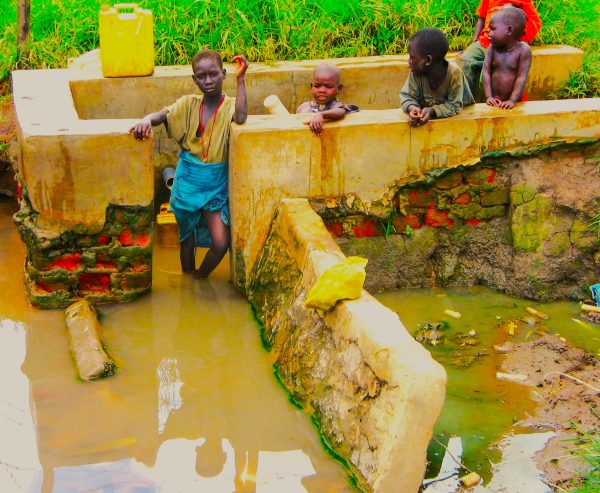 children collecting drinking water from unprotected well. (1)